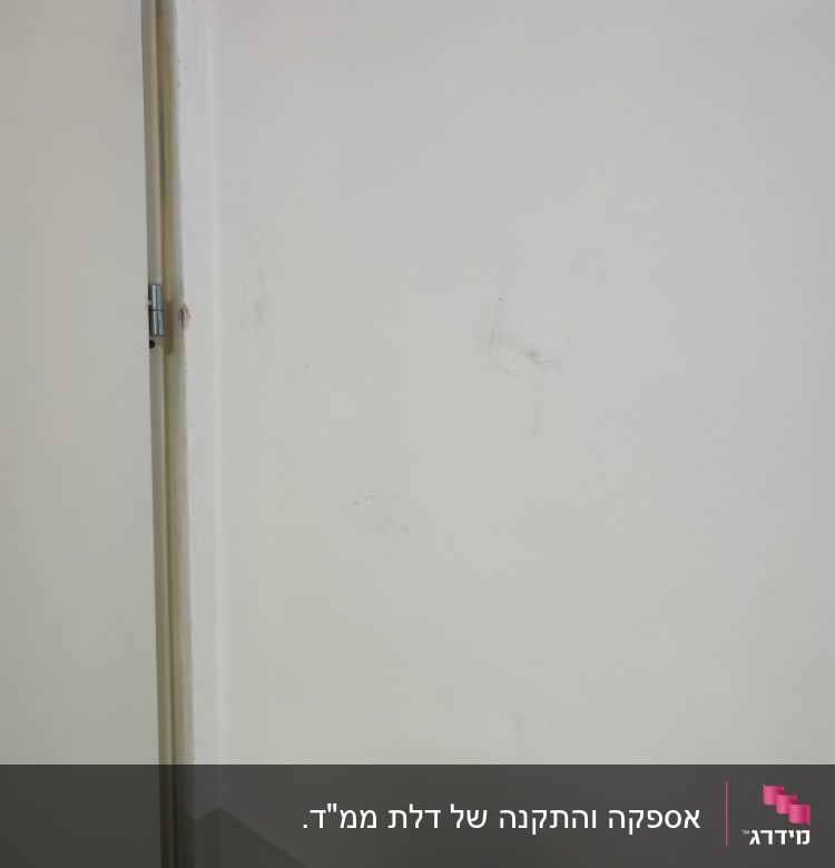 דלת לבנה עם מנעול על קיר לבן